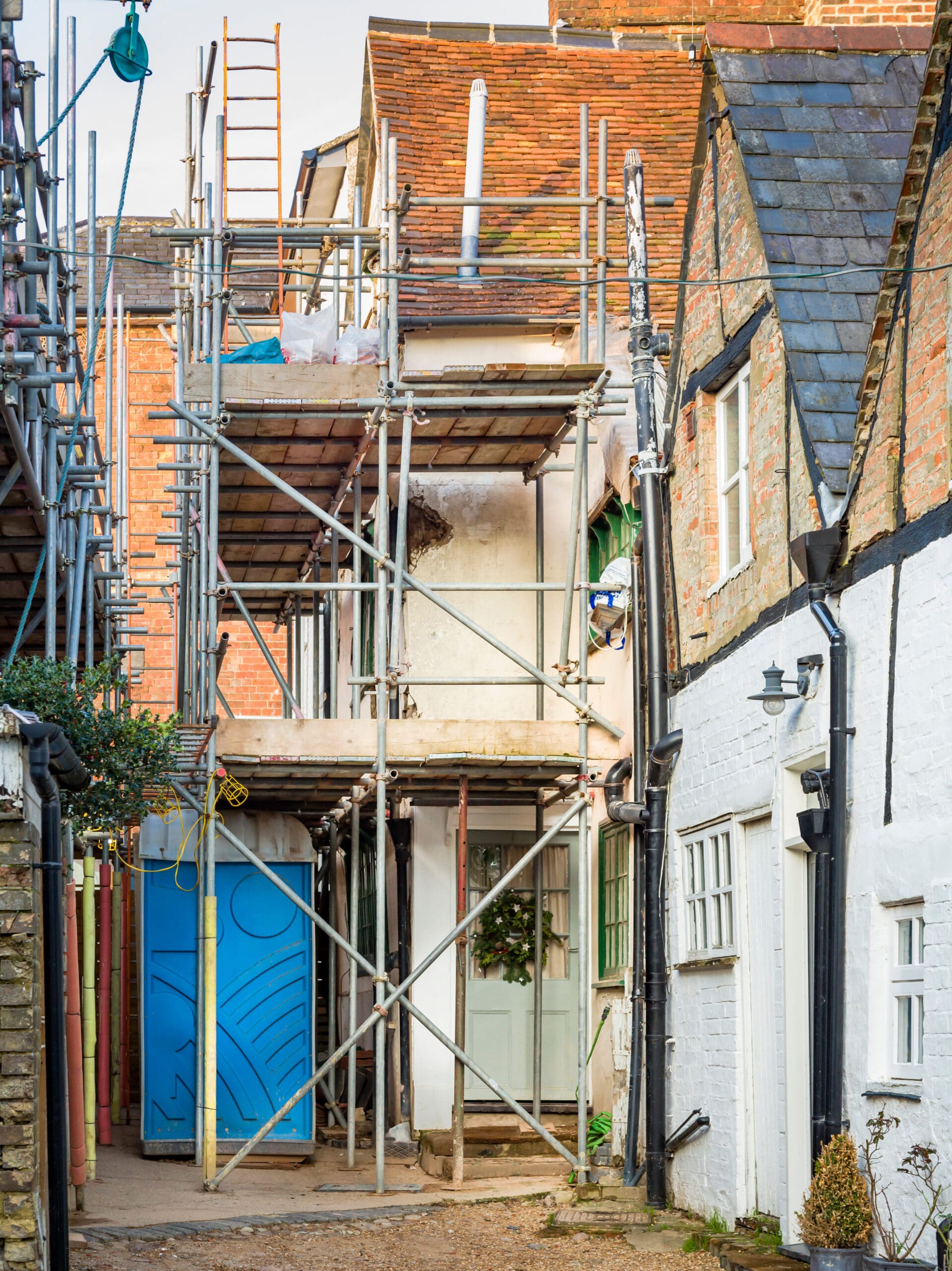 English house with scaffolding having building work and roof renovations, UK