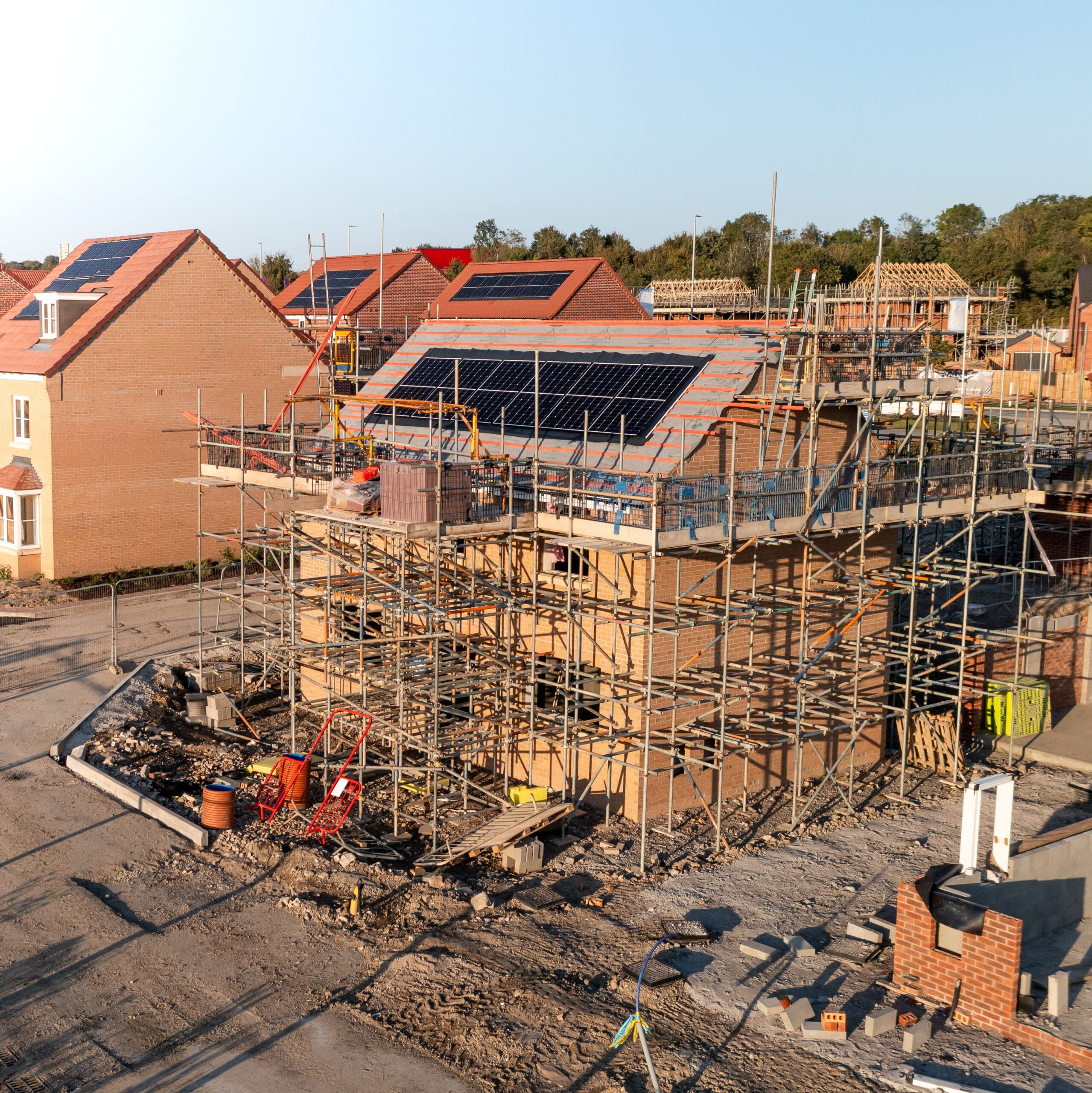 Aerial view of new build energy efficient and eco friendly homes with integrated rooftop solar panels generating renewable domestic energy on a house building development